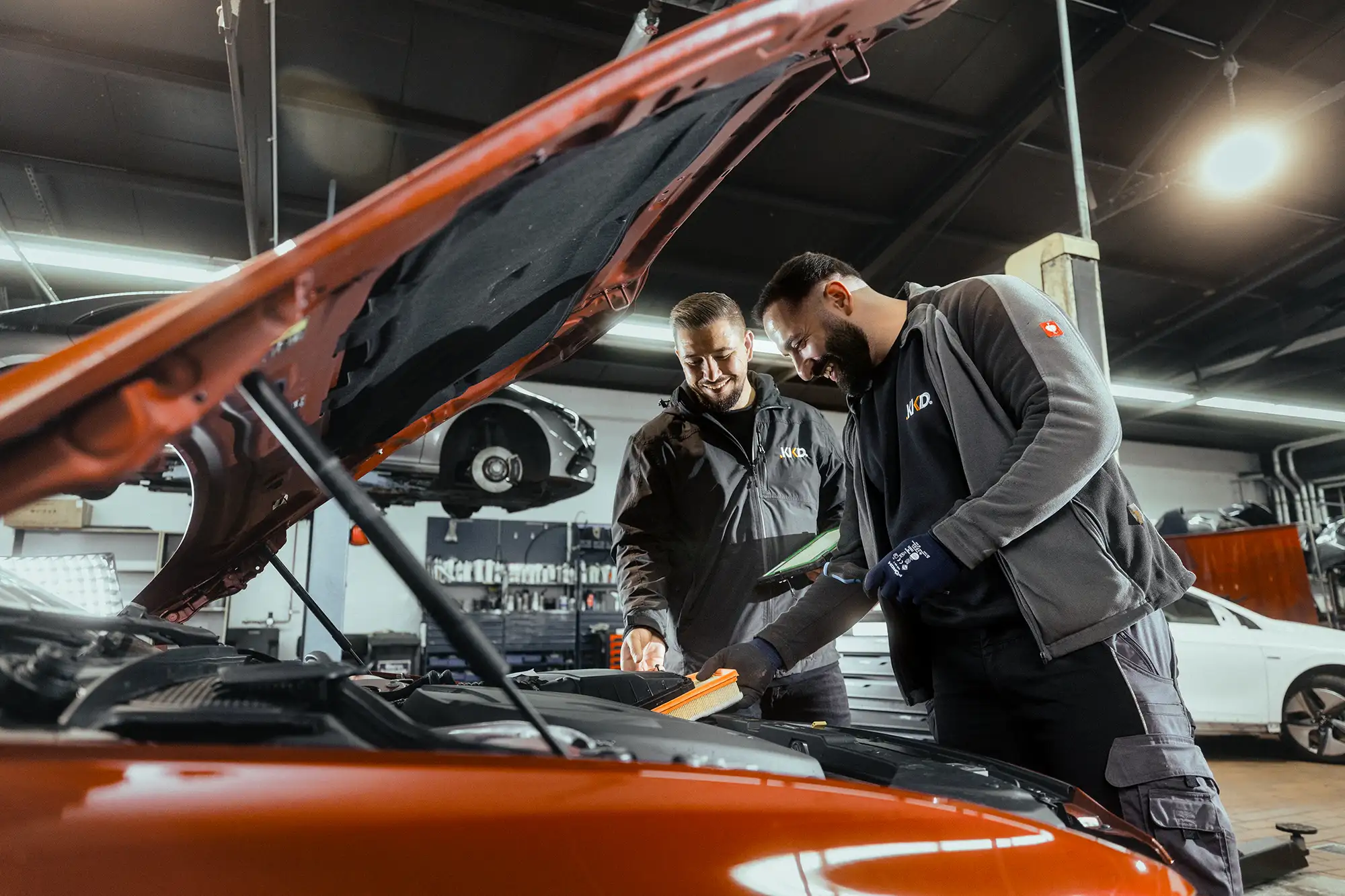Zwei Techniker von KKD Essen bei der Arbeit an einer Motorhaube